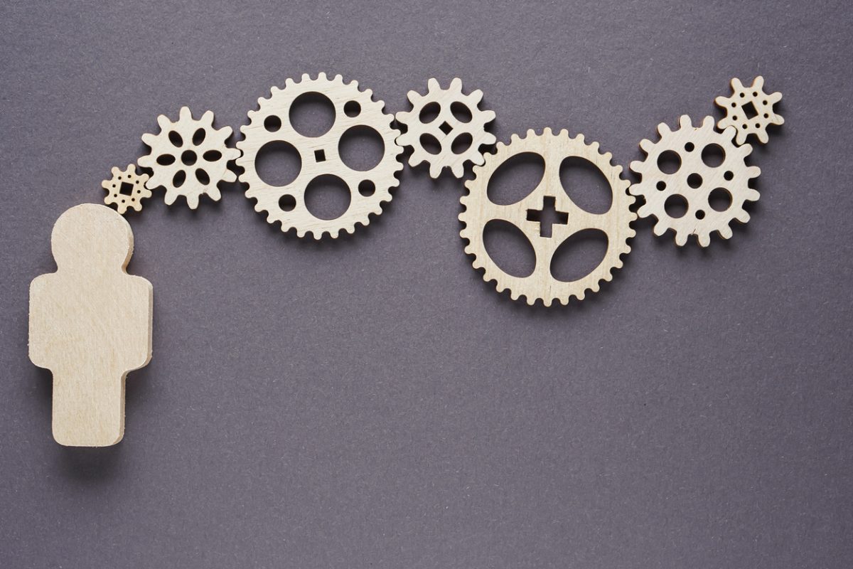 Abstract man with gears on gray background - concepts of business,  functioning, efficiency, interlocking parts.